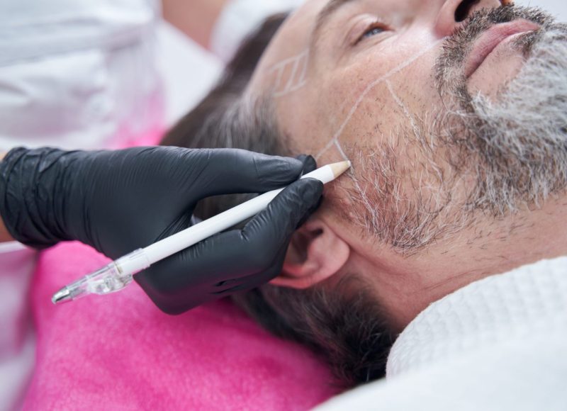 Relaxed male person lying on the couch while doing face care procedure
